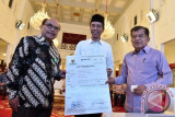 Presiden Joko Widodo (tengah) didampingi Wapres Jusuf Kalla (kanan) menerima bukti setor zakat dari Kepala Badan Zakat Nasional Bambang Sudibyo (kiri) di Istana Negara, Jakarta, Rabu (14/6/2017). Presiden membayar zakat penghasilan senilai Rp45 juta dari dasar pengenaan zakat mencapai Rp1,8 miliar. (ANTARA FOTO/Puspa Perwitasari)