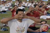 Sejumlah warga melakukan gerakan Yoga bersama di Lapangan Puputan Margarana, Denpasar, Bali, Minggu (18/6). Kegiatan tersebut dilakukan untuk memperingati Hari Yoga Internasional yang jatuh pada 21 Juni sekaligus memasyarakatkan seni dan manfaat gerakan-gerakan yoga untuk menjaga kesehatan dan kebugaran tubuh. ANTARA FOTO/Fikri Yusuf/wdy/17.
