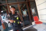 Anggota polisi berjaga di depan pintu Kantor DPRD Kota Mojokerto saat penggeledahan Komisi Pemberantasan Korupsi (KPK) memasuki kantor DPRD Kota Mojokereto, Jawa Timur, Minggu (18/6). Penyidik KPK menetapkan Ketua DPRD Kota Mojokerto Purnomo dan dua wakilnya, Umar Faruq dan Abdullah Fanani tersangka korupsi kasus pengalihan anggaran Dinas Pekerjaan Umum dan Penataan Ruang Kota Mojokerto 2017. Antara Jatim/Syaiful Arif/zk/17