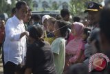 Presiden Joko Widodo (kiri) membagikan sembako kepada warga di Kampung Ciawi, Kota Bogor, Jawa Barat, Rabu (21/6). Sebanyak 3000 paket sembako dibagikan dalam kegiatan tersebut. ANTARA FOTO/Rosa Panggabean/wdy/17.