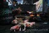 Seorang pekerja membakar kulit dan kaki sapi untuk membersihkan rambut di Pasar Kota, Bojonegoro, Jawa Timur, Rabu (21/6). Harga daging sapi murni di pasar tradisional setempat mulai merangkak naik menjadi Rp110 ribu per kilogram, yang sebelumnya Rp105 ribu per kilogram, menjelang Hari Raya Idul Fitri. Antara Jatim/Aguk Sudarmojo/zk/17.