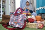 Perajin mengerjakan pembuatan rajutan tas di industri rumahan Sariz by Sarizein 90 di Pancagalih, Sindangbarang Loji, Kota Bogor, Jawa Barat, Selasa (20/6). Kerajinan rajutan tangan dari bahan benang nilon menjadi berbagai produk seperti bros, tas, pouch, sepatu rajut dan aplikasi renda rajut tersebut dipasarkan melalui sosial media ke sejumlah daerah di Indonesia hingga mancanegara Singapura dengan harga mulai Rp.100 ribu hingga Rp.500 ribu tergantung model, bahan dan ukuran. (ANTARA FOTO/Arif Firmansyah/17).