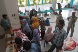 Sejumlah pasien menunggu pelayanan dari petugas di Rumah Sakit Umum Daerah (RSUD) dr Zubir Mahmud, Kabupaten Aceh Timur, Aceh, Kamis (22/6). Ratusan pasien kecewa akibat kurang maksimalnya pelayanan dari pihak rumah sakit sehingga pasien harus mengantre untuk mengambil obat dari pukul 8.00 WIB sampai pukul 17.00 WIB. (ANTARA FOTO/Syifa Yulinnas)