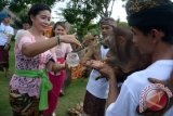 Seorang umat Hindu memercikkan air suci kepada sejumlah hewan saat upacara Tumpek Kandang di Bali Zoo, Gianyar, Bali, Sabtu (24/6). Umat Hindu Bali menggelar upacara ruwatan Hari Tumpek Kandang atau hari suci untuk hewan peliharaan dengan harapan hewan tersebut dapat berkembang dengan baik, harmonis, terjaga kelestariannya, dan memberi manfaat positif bagi manusia. ANTARA FOTO/Wira Suryantala/wdy/17.