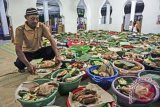 Warga menata nasi kenduri berisi ingkung (ayam) saat Rosulan Ingkung di Masjid Ar-Rahman, Dusun Kirobayan, Tirtosari, Kretek, Bantul, DI Yogyakarta, Sabtu (24/6). Tradisi Rosulan Ingkung yang diadakan setiap malam takbiran sejak tahun 1825 tersebut sebagai wujud syukur warga atas berakhirnya bulan suci Ramadan serta sebagai ajang bersilaturahmi warga yang merantau dan kembali ke kampung halaman. ANTARA FOTO/Hendra Nurdiyansyah/ama/17.
