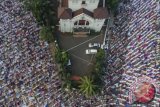 Foto aerial ribuan umat muslim mengikuti salat Idul Fitri 1438 H di Jatinegara, Jakarta Timur, Minggu (25/6). Pemerintah menetapkan hari raya Idul Fitri 1438 H jatuh pada hari ini Minggu (25/6). ANTARA FOTO/Sigid Kurniawan/hp/17.