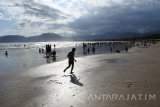 Pengunjung menikmati liburan di Pantai Pulau Merah, Pesanggaran, Banyuwangi, Jawa Timur, Selasa (27/6). Pada H+1 Lebaran kawasan wisata Pulau Merah ramai pengunjung.
Antara Jatim/Seno/zk/17.