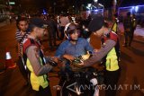 Sejumlah anggota Satsabhara Polrestabes Surabaya melakukan pemeriksaan terhadap pengendara roda dua ketika berlangsungnya Operasi Cipta Kondisi di Kawasan Raya Gubeng Surabaya, Jawa Timur, Minggu (2/7) dini hari. Dalam kegiatan tersebut jajaran Polrestabes Surabaya dan gabungan TNI mengamankan pengendara yang kedapatan membawa pil koplo, puluhan petasan dan kembang api, menilang 82 motor dan mobil yang bertujuan untuk memberikan rasa aman dan nyaman pada masyarakat Surabaya dan sekitarnya dari tindak kejahatan. Antara Jatim/M Risyal Hidayat/zk/17