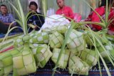 Pedagang musiman merangkai janur menjadi kulit ketupat di pasar Setono Bethek, Kota Kediri, Jawa Timur, Jumat (30/6). Menjelang tradisi Lebaran Ketupat yang biasanya dimulai pada hari ke enam Idul Fitri, anyaman janur sebagai kulit ketupan seharga Rp7.000 per sepuluh buah tersebut ramai diburu warga. Antara Jatim/Prasetia Fauzani/zk/17