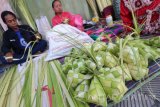 Pedagang musiman merangkai janur menjadi kulit ketupat di pasar Setono Bethek, Kota Kediri, Jawa Timur, Jumat (30/6). Menjelang tradisi Lebaran Ketupat yang biasanya dimulai pada hari ke enam Idul Fitri, anyaman janur sebagai kulit ketupan seharga Rp7.000 per sepuluh buah tersebut ramai diburu warga. Antara Jatim/Prasetia Fauzani/zk/17