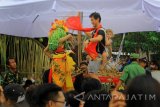 Penari seblang menari bersama wisatawan di Olesari, Banayauwangi, Jawa Timur, Sabtu (1/7). Tari seblang Olesari merupakan tradisi suku Osing yang dilakukan selama 7 hari setelah hari raya Idul fitri sebagai ritual bersih Desa. Antara Jatim/Budi Candra Setya/zk/17.