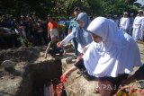 Putri dari almarhum Peltu LPU Budi Santoso, Saraswati (kedua kanan) menaburkan bunga diatas pusara almarhum di Tempat Pemakaman Umum (TPU) Bligo, Sidoarjo, Jawa Timur, Senin (3/7). Almarhum Peltu LPU Budi Santoso satu dari korban kecelakaan helikopter milik Basarnas di Gunung Butak, Temanggung, Jawa Tengah tersebut menewaskan delapan orang yang terdiri dari empat kru helikopter Dauphin AS365N3+ Reg HR-3602 dan empat tim Basarnas. Antara Jatim/M Risyal Hidayat/zk/17