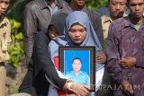 Putri dari almarhum Peltu LPU Budi Santoso, Saraswati membawa potret almarhum di Tempat Pemakaman Umum (TPU) Bligo, Sidoarjo, Jawa Timur, Senin (3/7). Almarhum Peltu LPU Budi Santoso satu dari korban kecelakaan helikopter milik Basarnas di Gunung Butak, Temanggung, Jawa Tengah tersebut menewaskan delapan orang yang terdiri dari empat kru helikopter Dauphin AS365N3+ Reg HR-3602 dan empat tim Basarnas. Antara Jatim/M Risyal Hidayat/zk/17