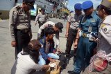 Petugas gabungan memeriksa dokumen dan barang bawaan penumpang kapal laut yang baru tiba di Pelabuhan Benoa, Bali, Senin (3/7). Sebanyak 36 orang dari 1.600 penumpang teridentifikasi tanpa dilengkapi dokumen identitas sehingga diserahkan ke tim penegak perda untuk diproses sesuai aturan penduduk pendatang. Antara Bali/Wira Suryantala/nym/17.