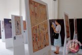 Pengunjung saat mengamati lukisan kulit kayu pada pameran Budjung yakni pameran kolaborasi seni tradisi Makassar-Aborigin di Museum Kota Makassar, Sulawesi Selatan. Pameran tersebut menampilkan koleksi tembikan asal Takalar oleh seniman Yirrkala serta lukisan kulit kayu karya peluki asal Nothern Territory dari koleksi Museum Nasional Australia. (ANTARA FOTO/Sahrul Manda Tikupadang/Dok).