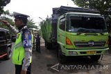 Petugas kepolisian mengatur lalu lintas di samping truk bermuatan pupuk yang bertabrakan dengan bus di Jalan Raya wisata Pantai Bentar, Gending, Probolinggo, Jawa Timur, Jumat (14/7). Kecelakaan maut antara bus dengan truk tersebut mengakibatkan 10 penumpang tewas, 2 diantaranya warga negara asing dan 9 luka. Antara Jatim/Umarul Faruq/zk/17