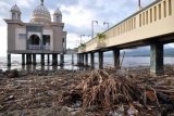 Sampah menumpuk di sekitar masjid terapung di Pantai Teluk Palu, Sulawesi Tengah, Kamis (13/7). Sampah yang hanyut bersama air hujan dan luapan air sungai tersebut selain mengganggu keindahan, juga mengganggu kenyamanan pengunjung ke salah satu lokasi wisata di Kota Palu tersebut. ANTARA FOTO/Mohamad Hamzah/ama/17.