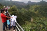 Sejumlah wisatawan menikmati pemandangan jalur alira lahar gunung Kelud di desa Sugihwaras, Kediri, Jawa Timur, Sabtu (15/7). Saat musim libur panjang sekolah destinasi wisata andalan Kediri tersebut mengalami peningkatan jumlah kunjungan yakni rata-rata 1.000 orang per hari di banding hari biasa yang rata-rata hanya 250 orang per hari. Antara Jatim/Prasetia Fauzani/zk/17