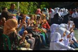 Sejumlah orang tua dan siswa berfoto bersama pada hari pertama sekolah tahun ajaran baru di Kabupaten Ciamis, Jawa Barat, Senin (17/7). Hari pertama masuk sekolah tahun ajaran 2017-2018 dimulai serentak di Indonesia pada Senin (17/7) dan para orang tua siswa hadir mengantar anaknya untuk berinteraksi dengan pihak sekolah. ANTARA FOTO/Adeng Bustomi/ama/17