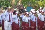 Guru membetulkan posisi hormat siswa  baru saat mengikuti upacara bendera di SDN Kowel 3, Pamekasan, Jawa Timur, Senin  (17/7). Senin, 17 Juli 2017 merupakan hari pertama masuk sekolah tahun ajaran 2017/2018.  Antara Jatim/Saiful Bahri/zk/17