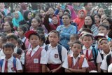 Siswa Sekolah Dasar dan wali murid pengantar mendengarkan instruksi guru pada hari pertama masuk sekolah di Sekolah Dasar 245 Palembang, Sumsel, Senin (17/7). Hampir seluruh sekolah di Kota Palembang memulai tahun ajaran baru 2017-2018 pada Senin (17/7). ANTARA FOTO/Feny Selly/ama/17