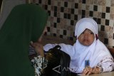 Fani Dwi Puspitasari berusaha membujuk putrinya, Azura yang menangis pada hari pertama masuk sekolah di Sekolah Dasar (SD) Muhammadiyah 18, Surabaya, Jawa Timur, Senin (17/7). Hari pertama masuk sekolah untuk tahun ajaran 2017-2018 tersebut secara serentak dimulai pada Senin (17/7). Antara Jatim/Moch Asim/zk/17