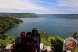 Sejumlah wisatawan berfoto dengan menggunakan handphone dengan latar belakang Danau Toba di Kawasan Prapat, Simalungun, Sumatera Utara, Minggu (16/7). IM3 Ooredoo saat ini telah menyediakan layanan 4G yang bisa dinikmati oleh wisatawan dan masyarakat di kawasan Danau Toba. www.antarasumut.com/Septianda Perdana/17