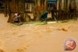 Warga berupaya memindahkan material yang terbawa banjir akibat meluapnya Sungai Batu Merah, di kawasan Ahuru, Kecamatan Sirimau, Ambon, Maluku, Senin (17/7). Selain bencana banjir, hujan deras yang mengguyur Kota Ambon sepanjang hari juga mengakibatkan tanah longsor di sejumlah lokasi. ANTARA FOTO/izaac mulyawan/aww/17.