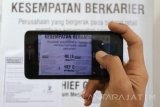 Seorang pencari kerja memotret info lowongan denganmenggunakan telepon genggam saat pembukaan bursa kerja yang diselenggarakan oleh pemerintah daerah setempat di Gor Jayabaya, Kota Kediri, Jawa Timur, Selasa (18/7). Bursa kerja yang menawarkan 500 lowongan kerja dari 62 perusahaan berbagai bidang tersebut ditargetkan mampu menyerap seribu tenaga kerja baru. Antara Jatim/Prasetia Fauzani/zk/17