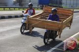 Penjual mebel membawa ranjang kayu memakai sepeda motor saat memasarkan produknya di Kartasura, Sukoharjo, Jawa Tengah, Kamis (20/7). Komunitas Industri Mebel dan Kerajinan Kayu Soloraya (KIMKAS) pada tahun ini berencana mengembangkan pasar mebel secara international dengan negara tujuan Afrika, India dan Eropa Timur setelah sebelumnya di Pasar Amerika serta Eropa Barat. ANTARA FOTO/Maulana Surya/wdy/17.