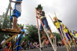 Sejumlah anak memainkan permainan tradisional egrang pada Festival Memengan di Banyuwangi, Jawa Timur, Sabtu (22/7). Festival yang menampilkan permainan tradisional oleh 5100 anak-anak tersebut, digelar sebagai upaya menjaga mainan tradisional tidak punah. Antara Jatim/Budi Candra Setya/zk/17.