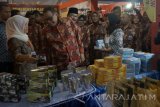 Menteri Koperasi dan UKM Anak Agung Gde Puspayoga kedua kiri )didampingi Gubernur Jawa Timur Soekarwo (kedua kanan)  melihat pameran koperasi dan UMKM dalam rangka memperingati puncak peringatan Hari Koperasi Nasional ke-70  se-Jatim di Tulungagung, Jawa Timur, Jumat (21/7). Menkop UKM menyatakan, pemerintah telah membubarkan lebih dari 43.000 koperasi 'tidak sehat', dan mengawasi 76 koperasi 'sakit' dalam upaya penyehatan perkoperasian nasional yang kini tersisa 76.000 unit di seluruh Indonesia. Antara Jatim/Destyan Sujarwoko/zk/17