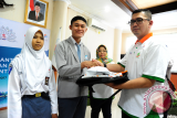 Direktur SDM dan Hukum PT Pelabuhan Indonesia II (Persero)/IPC, Rizal Ariansyah (kanan) secara simbolis menyerahkan atribut kepada siswa berprestasi dari Kalimantan Barat saat pembukaan sekaligus pelepasan Siswa Mengenal Nusantara (SMN) 2017 di Kantor PT Pelabuhan Indonesia II (Persero) Cabang Pontianak, Senin (24/7). Kegiatan SMN 2017 yang diadakan oleh PT Pelindo II (Persero)/IPC bersama PT Perkebunan Nusantara XIII serta diikuti 40 siswa berprestasi dari Kalbar dan Gorontalo tersebut, bertujuan agar siswa dapat saling mengenal keberagaman budaya, kekayaan alam, potensi daerah dan kewirausahaan. ANTARA FOTO/Jessica Helena Wuysang/17
