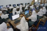 Guru memberi materi pembelajaran menjelang praktikum siswa di laboratorium bahasa SMKN 1 Tulungagung, Tulungagung, Jawa Timur, Senin (24/7). Sebanyak enam lembaga yang terdiri dari tiga SMA dan tiga SMK di daerah itu mulai memberlakukan ujicoba pelaksanaan pola pembelajaran lima hari kerja dalam sepekan sebagai persiapan penerapan program 'fullday school' dalam sistem pendidikan nasional. Antara Jatim/Destyan Sujarwoko/zk/17