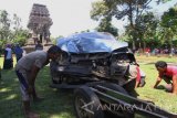 Warga melihat bangkai mobil bernopol  BE 2844 GH yang menabrak badan Candi Kidal, Malang, Jawa Timur, Selasa (25/7). Menurut polisi, pengendara mobil terbawa halusinasi sehingga tidak sadar jika dirinya menabrak pagar dan badan candi yang berjarak 20 meter dari jalan raya. Antara Jatim/Ari Bowo Sucipto/zk/17.