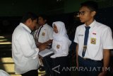 Wali Kota Kediri Abdullah Abu Bakar memberikan bantuan seragam sekolah secara simbolis pada pelajar di Kediri, Jawa Timur, Rabu (26/7). Pemkot memberikan bantuan seragam sekolah untuk 6 ribu pelajar SD, 7 ribu pelajar SMP, dan pelajar SMA/SMK hingga 11.800 siswa. Pendistribusian dilakukan di seluruh sekolah baik negeri dan swasta di Kota Kediri. Antara Jatim/Foto/Asmaul Chusna/zk/17