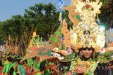 Peserta mengenakan buasan karnaval mengikuti kirab budaya 'Dongkrak Dongkrek' melintas di depan kantor Pemkab Madiun, Jawa Timur, Selasa (25/7). Kegiatan seni budaya tersebut dalam rangka memeriahkan Hari Jadi ke-449 Kabupaten Madiun. Antara Jatim/Foto/Siswowidodo/zk/17