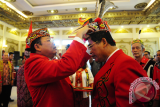 Presiden Majelis Adat Dayak Nasional (MADN) sekaligus Gubernur Kalbar, Cornelis (kiri) memasangkan topi adat kepada Ketua Dewan Adat Dayak (DAD) Kalbar, Jakius Sinyor (dua kanan) saat pengukuhan di Pendopo Gubernur Kalbar, Selasa (25/7). Pengukuhan pengurus Dewan Adat Dayak Kalbar periode 2017-2022 tersebut, merupakan rangkaian dari acara Kongres Dayak Internasional ke-I yang akan digelar di Pontianak pada 26-27 Juli 2017. ANTARA FOTO/Jessica Helena Wuysang/17