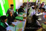 Bupati Banyuwangi Abdullah Azwar Anas (ketiga kiri) menyaksikan sidang nikah masal di Banyuwangi, Jawa Timur, Jumat (28/7). Sidang Isbat nikah masal yang melibatkan 112 pasangan suami istri tersebut, digelar untuk mengesahkan pernikahan guna memperlancar pengisian biodata seperti KTP, KK dan Akte kelahiran secara resmi. Antara Jatim/Budi Candra Setya/zk/17.