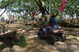 Wisatawan mengendarai motor ATV di areal objek wisata Taman Trembesi Kota Madiun, Jawa Timur, Minggu (30/7). Objek wisata hutan pohon trembesi tersebut dibuka sekitar sebulan yang lalu, namun sudah banyak dikunjungi wisatawan. Antara Jatim/Foto/Siswowidodo/zk/17