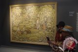 Pengunjung di depan lukisan karya pelukis Ida Bagus Made Poleng berjudul Sesadji Dewi Sri (1953) pada pembukaan pameran lukisan koleksi Istana Kepresidenan Republik Indonesia yang bertajuk 'Senandung Ibu Pertiwi', di Galeri Nasional, Jakarta, Selasa (1/8). Pameran tersebut akan berlangsung untuk umum hingga 30 Agustus 2017. ANTARA FOTO/Dodo Karundeng/foc/17.