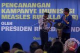 Presiden Jokowi (kanan) berdialog dengan pelajar saat acara Pencanangan Kampanye Imunisasi Measless Rubella (MR) di Madrasah Tsanawiah 10, Sleman, DI Yogyakarta, Senin (1/8). Kampanye imunisasi MR itu menjadi komitmen kuat pemerintah dalam mewujudkan eleminasi campak dan megendalikan rubella serta kecatatan bawaaan akibat rubela di Indonesia dengan strategi pemberian imunisasi MR untuk anak usia 9 bulan hingga 15 tahun. ANTARA FOTO/Andreas Fitri Atmoko/wdy/17.