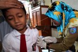 Petugas kesehatan dari Dinas Kesehatan Kota Tangsel memberikan suntikan imunisasi Measleas Rubela (MR) kepada sejumlah murid Sekolah Dasar (SD) di SDN Pamulang 1, Pamulang, Tangerang Selatan, Banten, Selasa (1/8). Pemerintah lewat Kementerian Kesehatan secara serentak melakukan Kampanye dan pemberian imunisasi MR kepada anak usia sembilan bulan hingga 15 tahun sebagai komitmen global untuk membasmi virus campak rubella yang bisa memicu kecacatan dan kematian pada anak.ANTARA FOTO/Muhammad Iqbal/pd/17