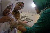 Bupati Tulungagung Sahri Mulyo (tengah) menyaksikan proses vaksinasi campak dan rubella kepada siswa SMPN 1 Tulungagung, di Tulungagung, Jawa Timur, Selasa (1/8). Dinas kesehatan setempat menargetkan vaksinasi terhadap 120 ribu anak mulai kelompok usia balita melalui gerakan posyandu keliling maupun jemput bola ke sekolah-sekolah tingkat SD-SMP guna mencegah penularan virus campak/rubella yang bisa menyebabkan kematian ataupun cacat tetap. ANTARA FOTO/Destyan Sujarwoko/foc/17.