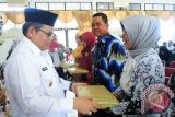 Bupati Balangan, H Ansharuddin, memberikan cendera mata bagi anggota PGRI yang melaksanakan purna tugas pada kegiatan saat halal bi halal Calon Jamaah Haji dan Purna Tugas anggota PGRI Kecamatan Paringin, Rabu (2/8), di Aula Gedung Sanggar Kegiatan Belajar (SKB) Kecamatan Paringin. Foto: (Roly Supriadi).