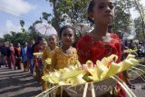 Warga dan anak-anak berpakaian adat mengarak aneka sesajen berbentuk kembang dan hasil bumi dalam rangkaian tradisi ulur-ulur di Telaga Buret, Tulungagung, Jawa Timur, Jumat (4/8). Tradisi ulur-ulur dengan melakukan ritual jamasan sepasang arca dewa perlambang kemakmuran dan kesuburan itu digelar setiap tahun dengan dasar penanggalan Jawa, sebagai wujud ungkapan rasa syukur petani kapada Tuhan atas limpahan air Telaga Buret yang menjadi sumber pengairan bagi pertanian sekitarnya. Antara Jatim/Destyan Sujarwoko/zk/17