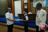 Kepala Dinas Komunikasi Informatika dan Statistik Kabupaten Tabalong, Imam Fahrullazi menyerahkan materi kepada salah satu peserta Sosialisasi Internet sehat bagi pelajar, Rabu di Gedung Informasi Tanjung. Sosialisasi ini bertujuan untuk memberikan wawasan soal internet, cara penggunaannya yang aman dan sehat.Foto Antaranews.Kalsel/Herlina LasmiantiK