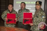 Panglima Kodam IX Udayana Mayor Jenderal TNI Komaruddin Simanjuntak (tengah) bersama Gubernur Bali, Made Mangku Pastika (kanan) dan Gubernur NTT, Frans Lebu Raya (kiri) memperlihatkan senjata api saat penyerahan senjata itu di Denpasar, Bali, Kamis (10/8). Senjata api itu diserahterimakan kepada Gubernur Bali, NTB dan NTT sebagai bentuk kehormatan telah mengikuti pembekalan dan latihan Pasukan Pemukul Reaksi Cepat TNI 2017 di Natuna sekaligus untuk melindungi diri sebagai kepala daerah. Antara Bali/Nyoman Budhiana/i018/2017.