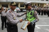 Kapolresta Pekanbaru Kombes Pol Susanto (kiri) memberikan penghargaan kepada Bripda Yoga Vernando anggota Polantas Polresta Pekanbaru yang menjadi korban pemukulan oknum TNI AD di halaman Mapolresta Pekanbaru, Riau, Jumat (11/8). Bripda Yoga Vernando mendapatkan penghargaan karena dinilai sudah menjalankan tugasnya dengan baik sebagai pengayom, pelayan dan pelindung masyarakat. ANTARA FOTO/Rony Muharrman/aww/17.