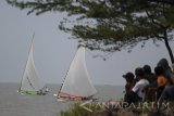 Sejumlah peserta beradu cepat saat mengikuti lomba perahu layar tradisional di kawasan Pantai Kenjeran, Surabaya, Jawa Timur, Sabtu (12/8). Kegiatan yang diikuti oleh 22 peserta tersebut merupakan tradisi bagi para nelayan setempat untuk memeriahkan HUT Ke-72 Kemerdekaan RI. Antara Jatim/Moch Asim/zk/17